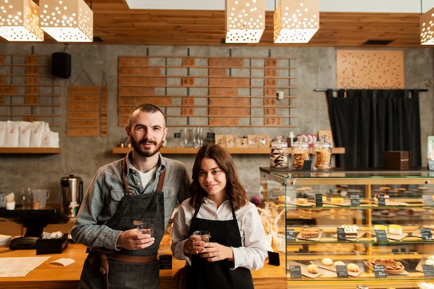 couple-aprons-posing-with-cups-coffee_23-2148366704.jpg